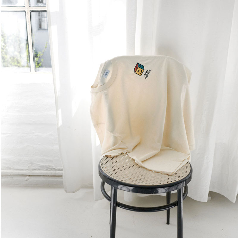 Choose Happiness T-Shirt auf einem Stuhl in einem hellen Raum